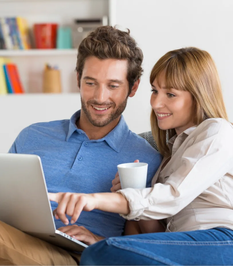 Couple d&eacute;contract&eacute; devant un ordinateur